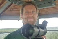 Porträt von Heiner Schumann mit Objektiv auf Beobachtunsplattform.